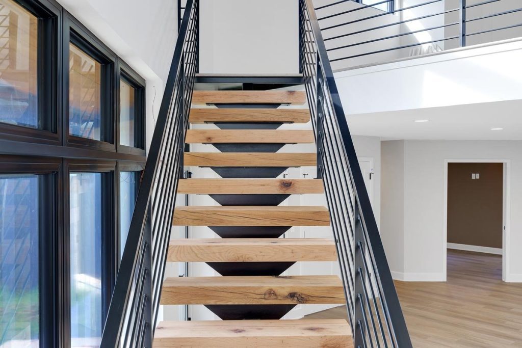 Solid stair treads with black steel stringer and horizontal steel rails
