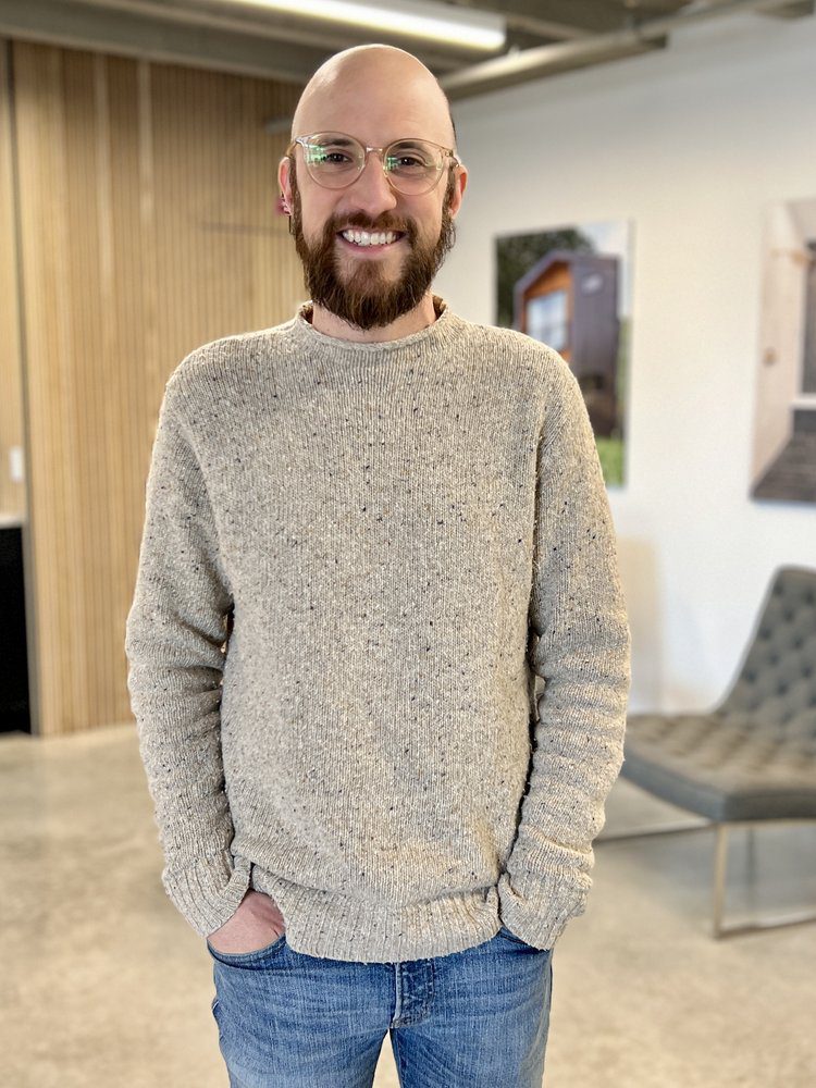 Brit Naylor, Louisville architectural designer, smiling in a modern, casual office setting.