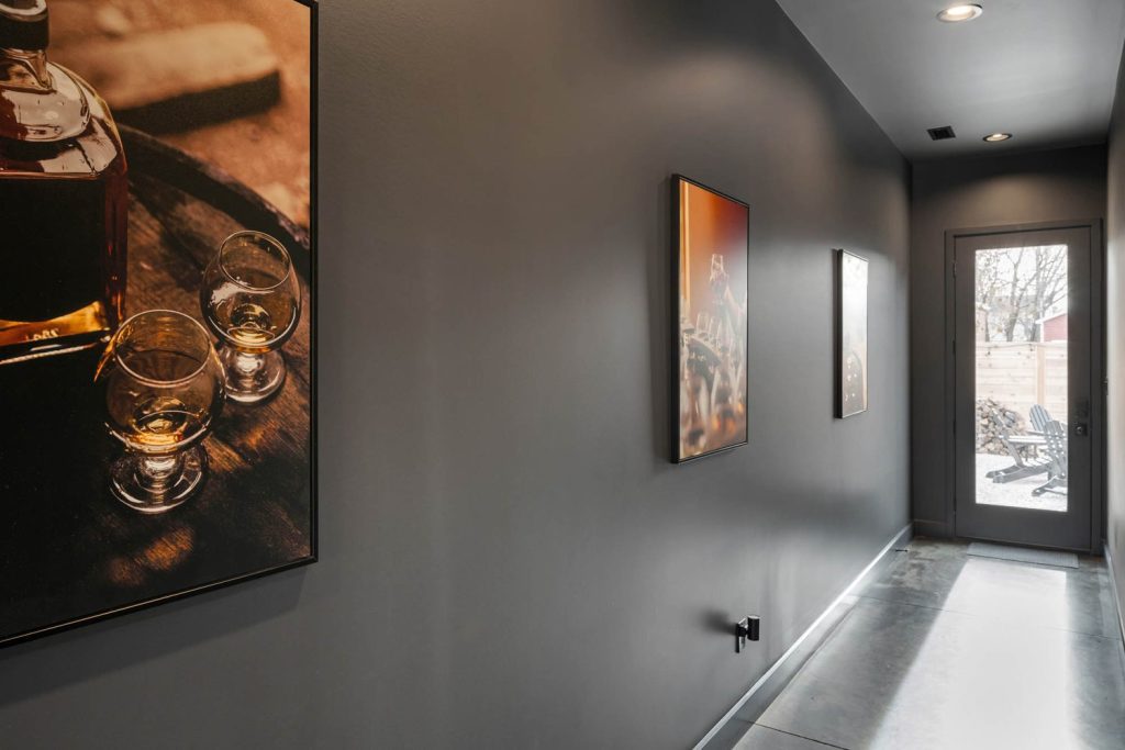 Louisville modern hallway with gray walls and framed whiskey artwork, creating a stylish, cozy, and sophisticated vibe.