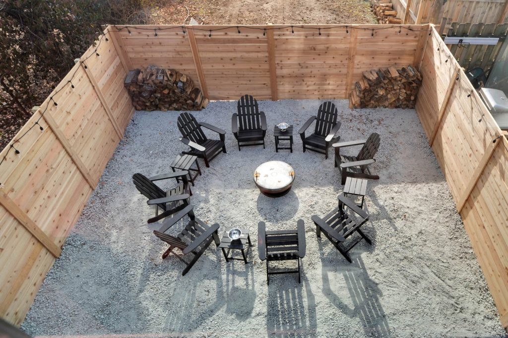 Louisville modern outdoor lounge with Adirondack chairs around a fire pit, cozy gravel seating area, and wood accents.