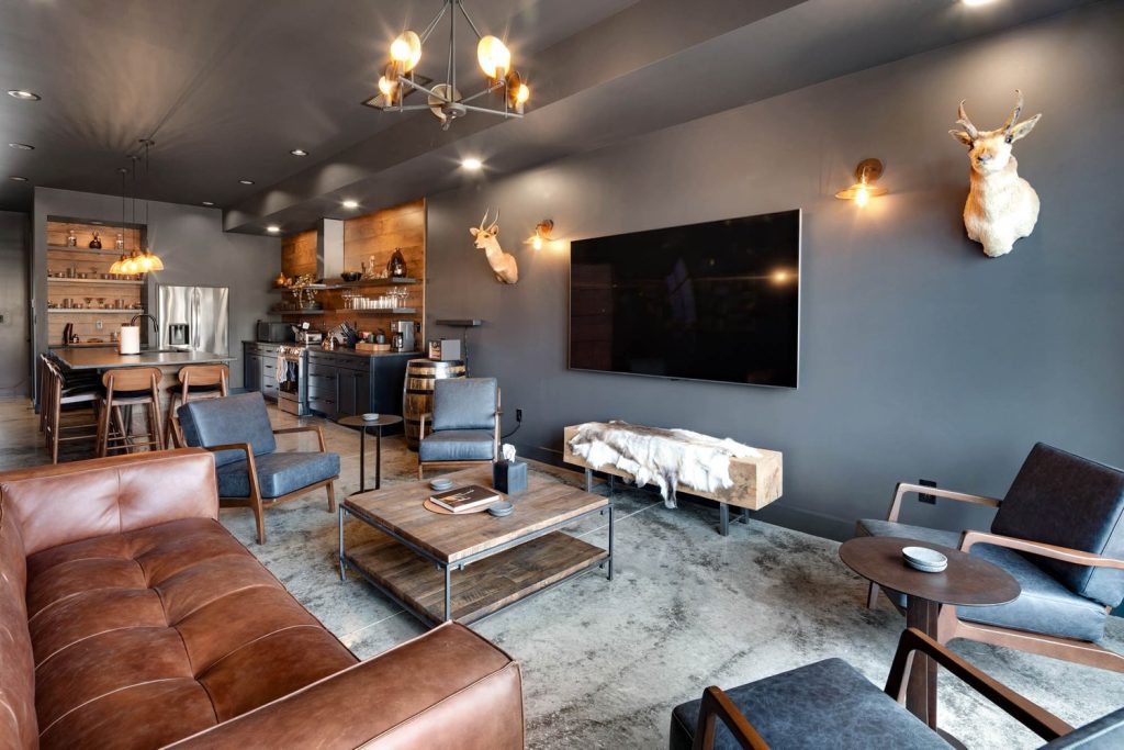 Louisville modern living room with brown leather sofas, large TV, and industrial lighting. Cozy, stylish design.