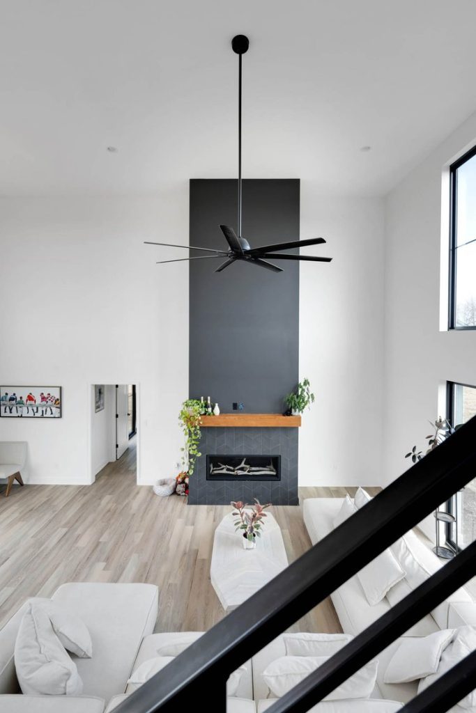 Bright Louisville Modern Living Room with Sleek Fireplace, Dark Accent Wall, White Sectional, and Greenery