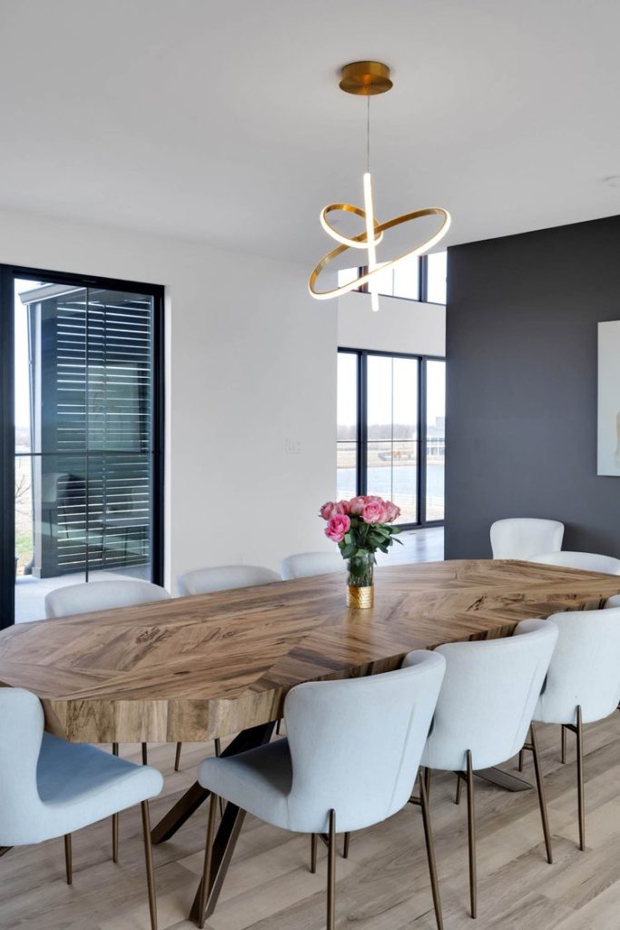Louisville modern dining room with wooden table, white chairs, pink floral centerpiece, and sleek pendant lighting.