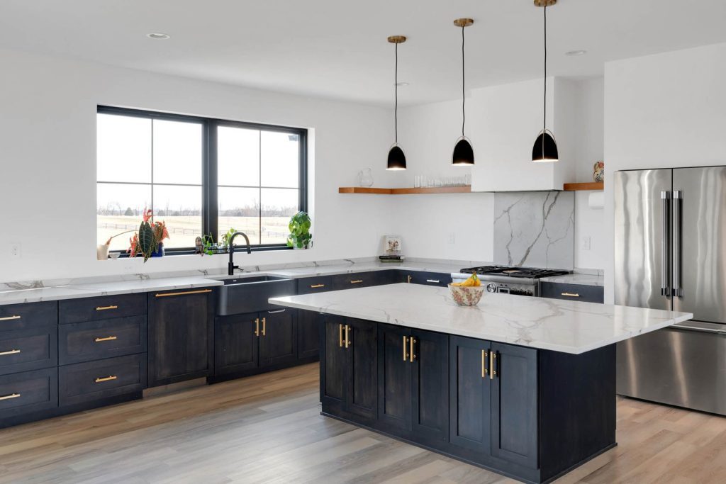 Louisville modern kitchen with dark wood cabinets, marble countertops, pendant lights, and bright outdoor views.