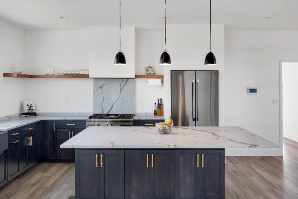 Optimized Alt Text: Louisville modern kitchen with dark cabinets, marble island, stainless steel fridge, and pendant lighting. Character Count (Alt Text): 123 Image Title: Elegant Louisville Modern Kitchen with Dark Cabinets, Marble Island, Stainless Steel Appliances, and Pendant Lights