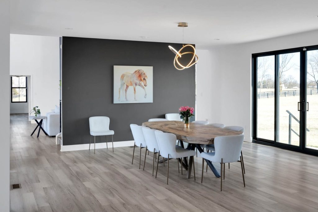 Louisville modern dining room with wooden table, gray chairs, pink flowers, horse art, and pendant lighting.