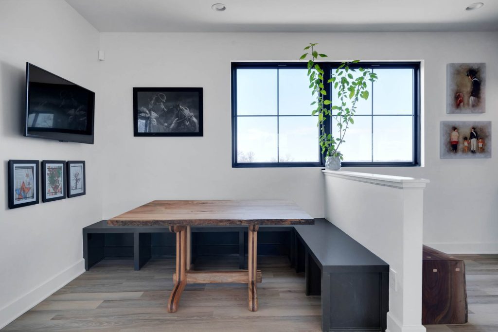 Louisville modern dining area with wooden table, black benches, potted plant, and elegant black-and-white wall art.