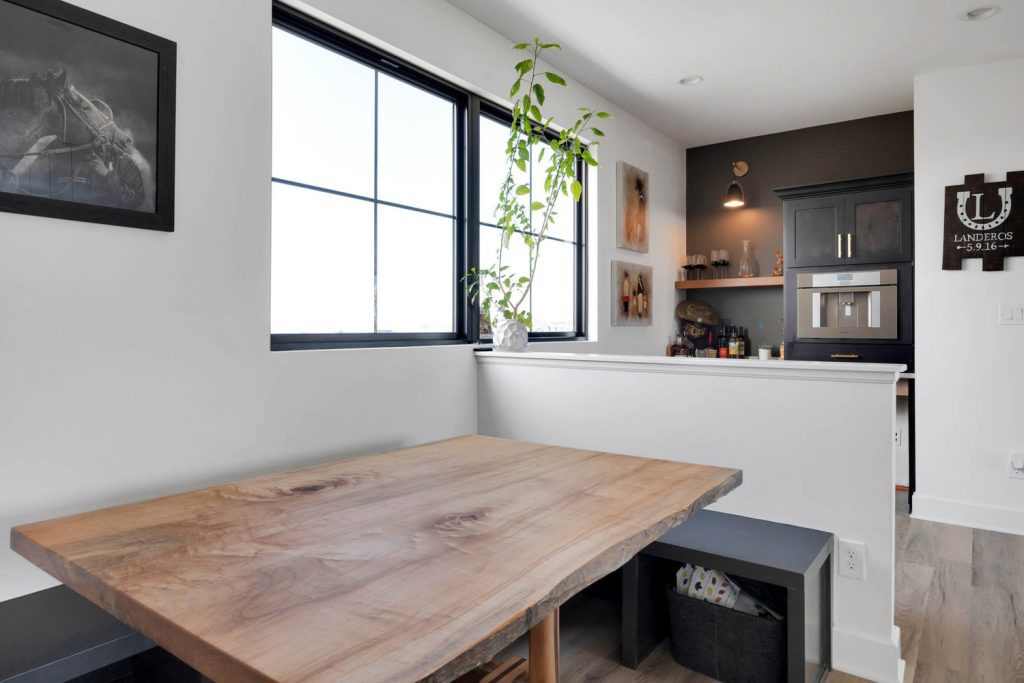 Louisville modern kitchen with light wood table, green plant, open shelving, and warm cozy lighting.