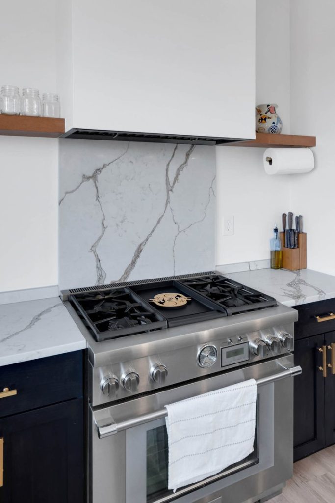 Louisville modern kitchen with stainless steel gas stove, marble backsplash, and minimalist countertop decor.
