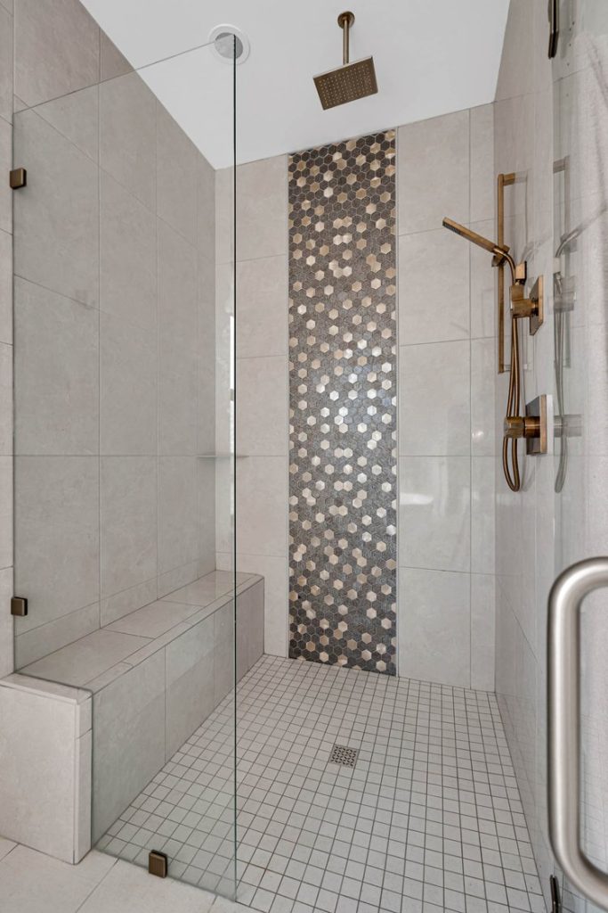 Louisville modern shower with gray tile walls, mosaic accent strip, and brass fixtures by top custom home builders.