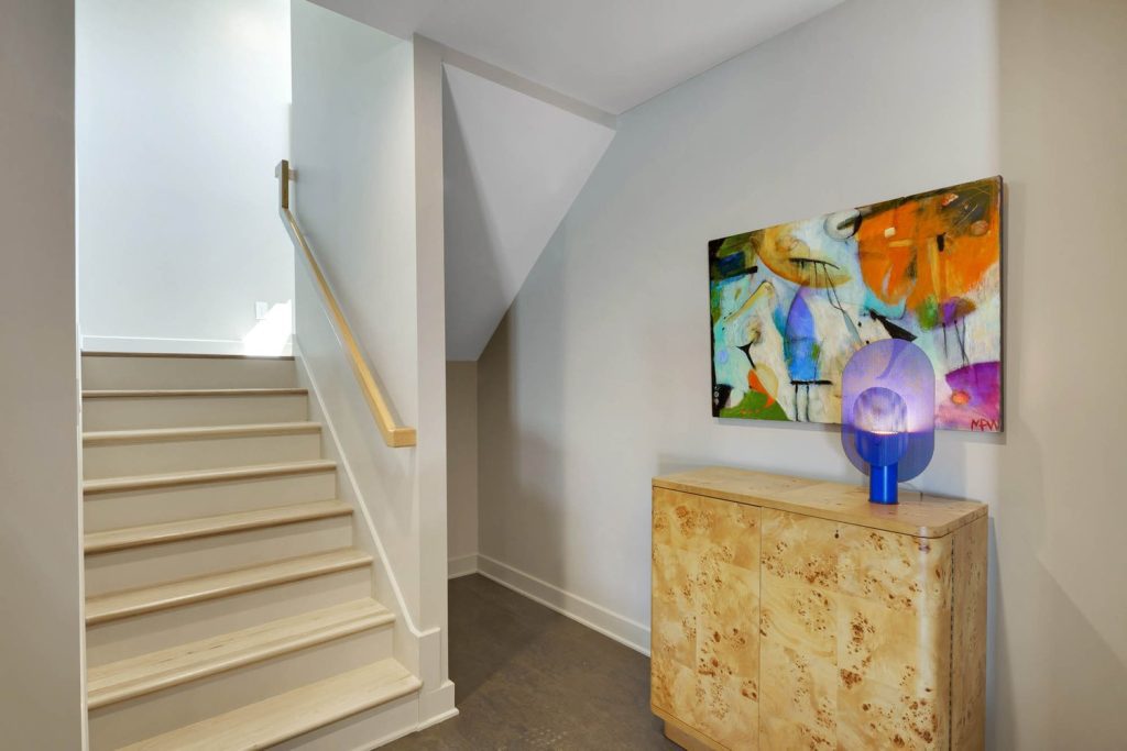Modern hallway, abstract art, and accent cabinet, showcasing new construction home design ideas