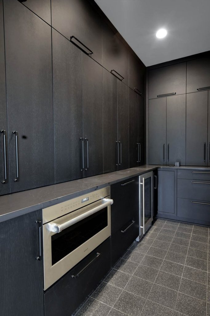 Sleek modern kitchen with matte black cabinets, stainless steel oven, minimalist handles, and a clean, contemporary look