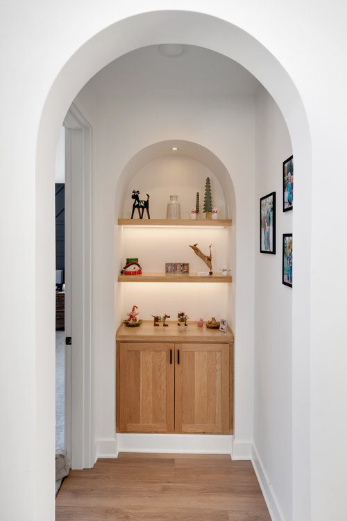 Modern alcove with wooden shelves and cabinet in Louisville home, designed by top custom home builders.