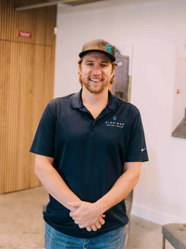 Nick Owen, Louisville senior project manager, smiling indoors with wood paneling and white walls.