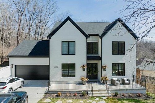 Elegant two-story Louisville custom home with white exterior, black trim, and modern design by Eldridge Company.