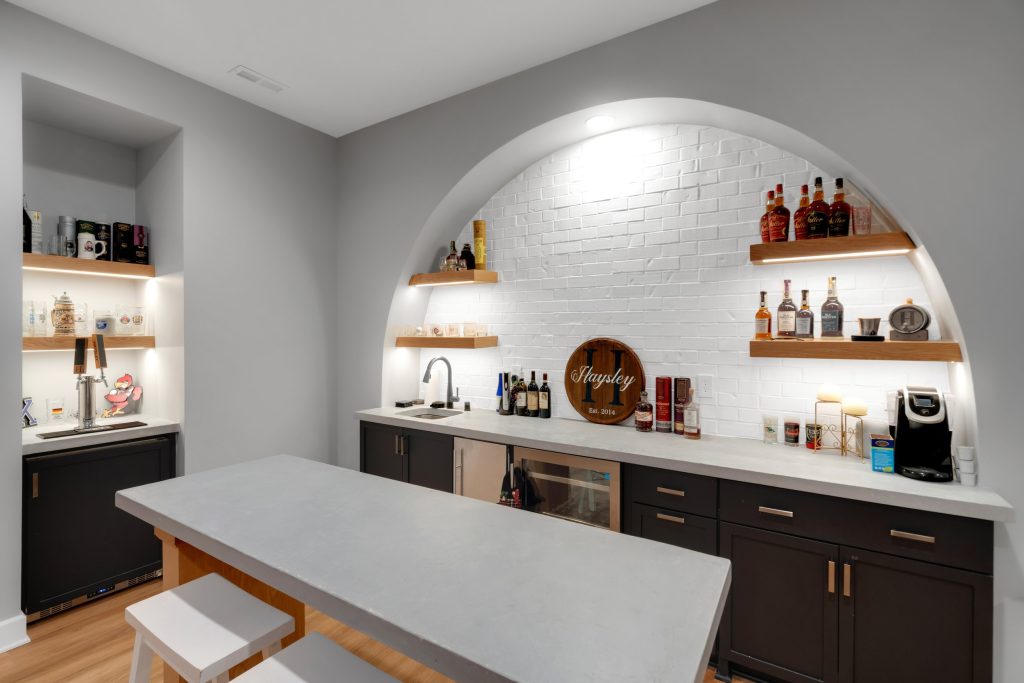 Louisville custom home design ideas bar with white counter, lit shelves, sink, and mini fridge by top modern home builders.