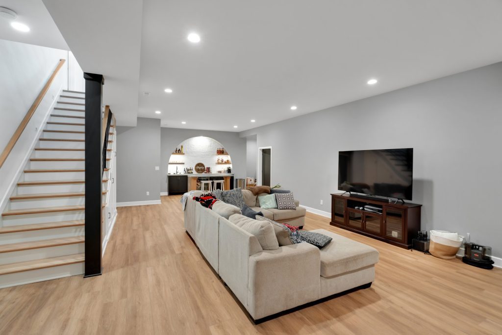 Louisville living room by top custom home builders showcasing new home design ideas with spacious seating and light wood floors.
