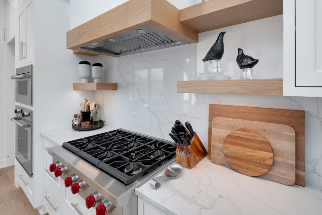 Louisville modern kitchen corner with gas stove, wooden shelves, and minimalist design by Eldridge Company.