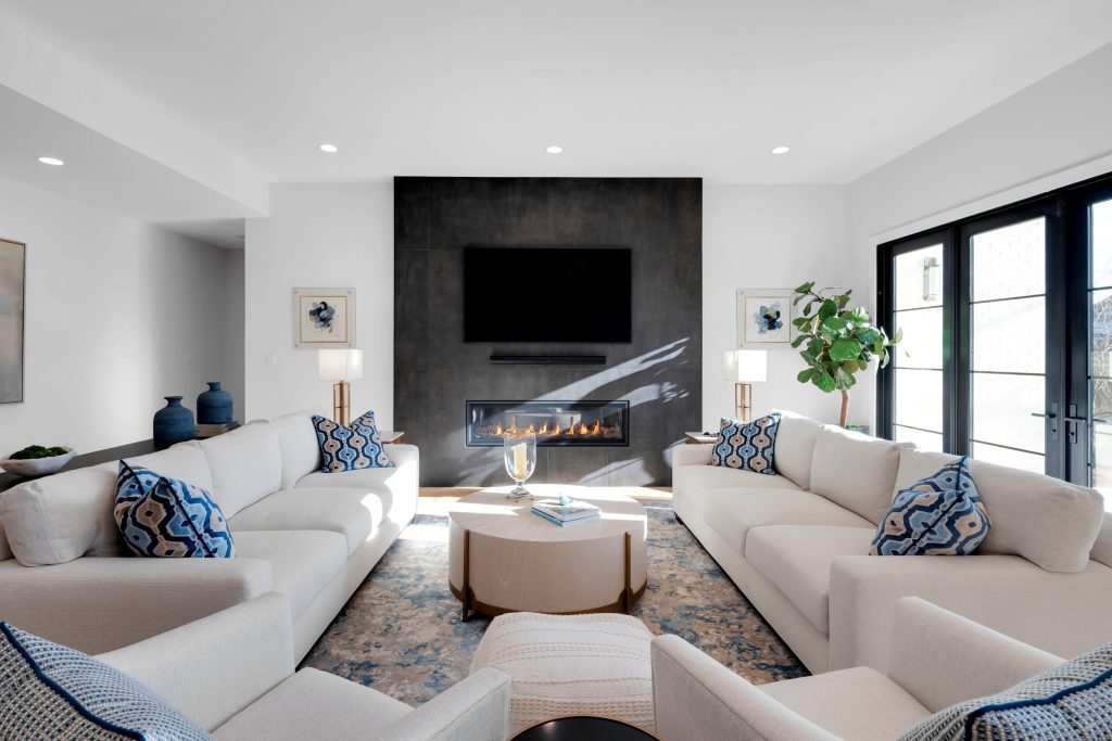 Louisville modern living room with white sofas, fireplace, and sleek TV by top custom home builders Eldridge Company.