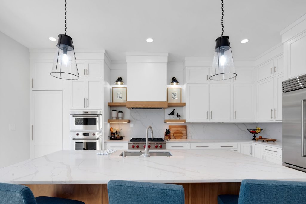 Louisville modern kitchen with white cabinets, marble island, and stainless steel oven by top custom home builders Eldridge Company.