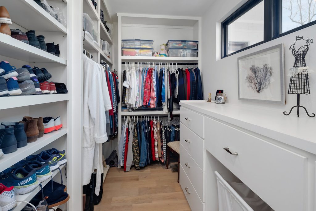 Louisville walk-in closet by top custom home builders showcasing custom home design ideas with organized storage and shelving.