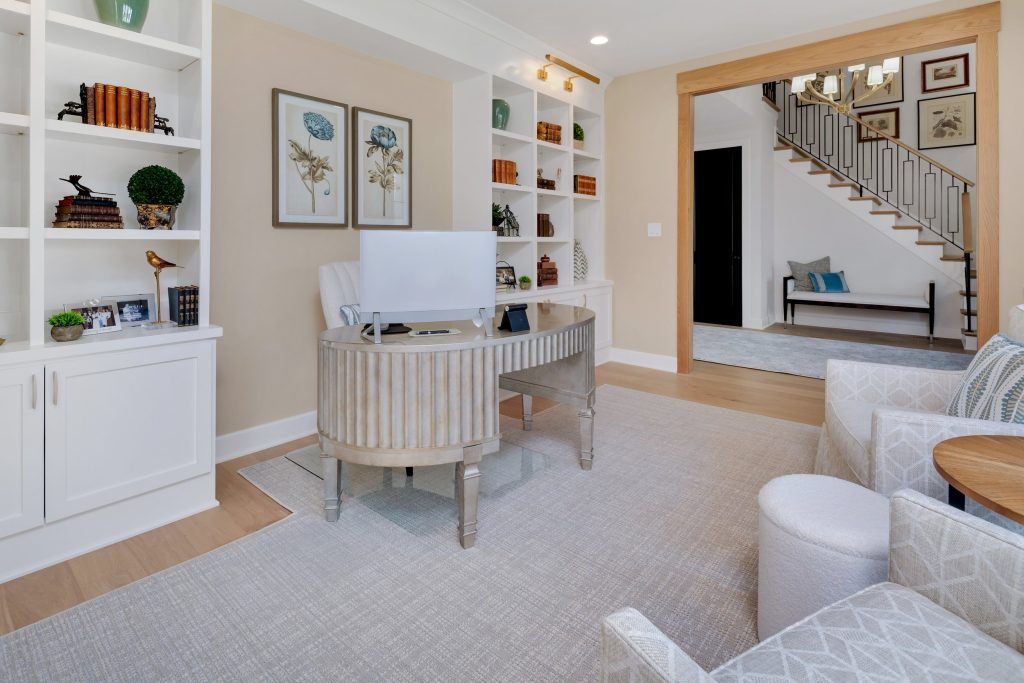 Louisville modern home office with curved desk, white chair, and nature-themed decor by top custom home builders.