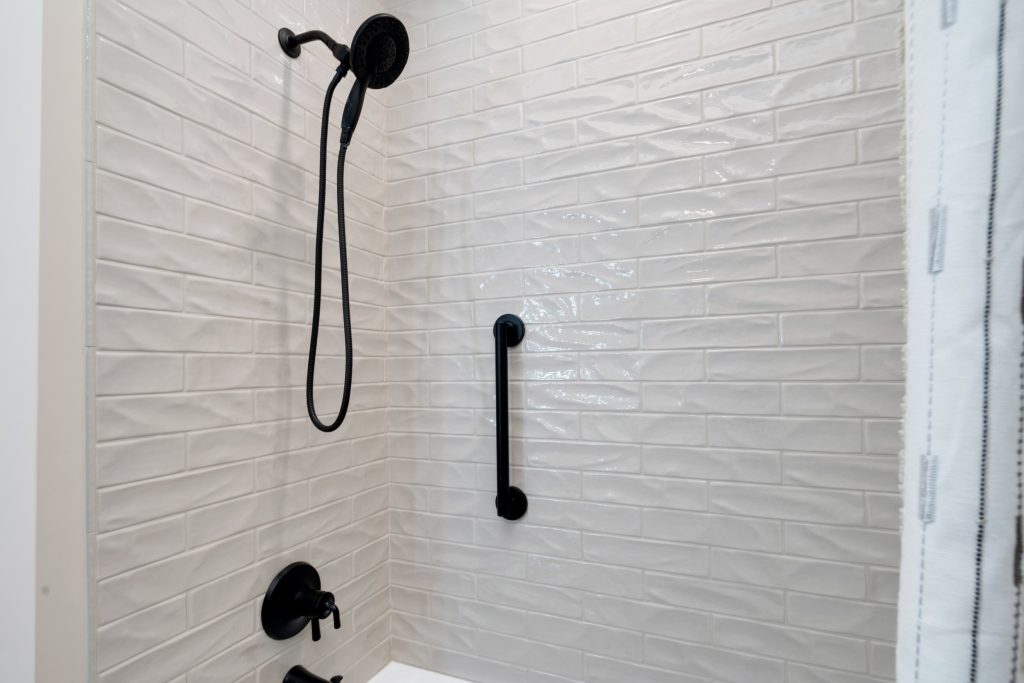 Louisville modern bathroom shower with white subway tiles and black fixtures by top custom home builders.