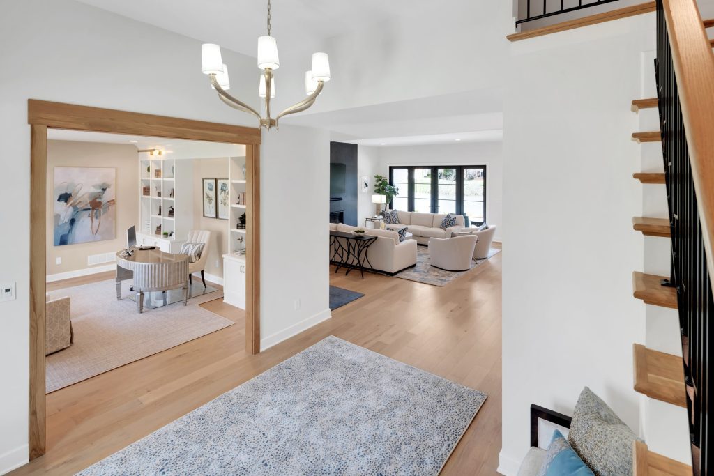 Louisville modern open-plan living space with chandelier, stylish seating, and large windows by top custom home builders.