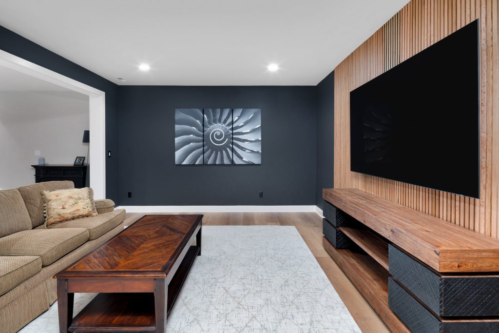 Louisville modern living room with dark accent wall, spiral artwork, and stylish décor by top custom home builders.