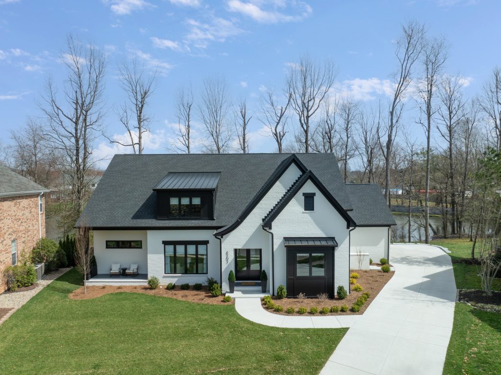 Modern Louisville home with black roof, large windows, and landscaped yard by top custom home builders