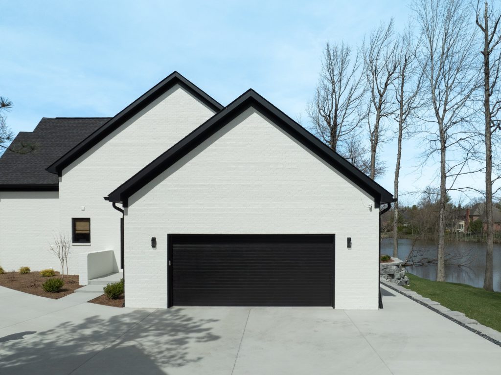 Louisville white home with black garage, gable roof, and river view by top custom home builders