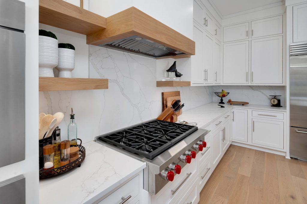 Louisville modern kitchen with white cabinets, marble countertops, and stainless steel stove by Eldridge Company.