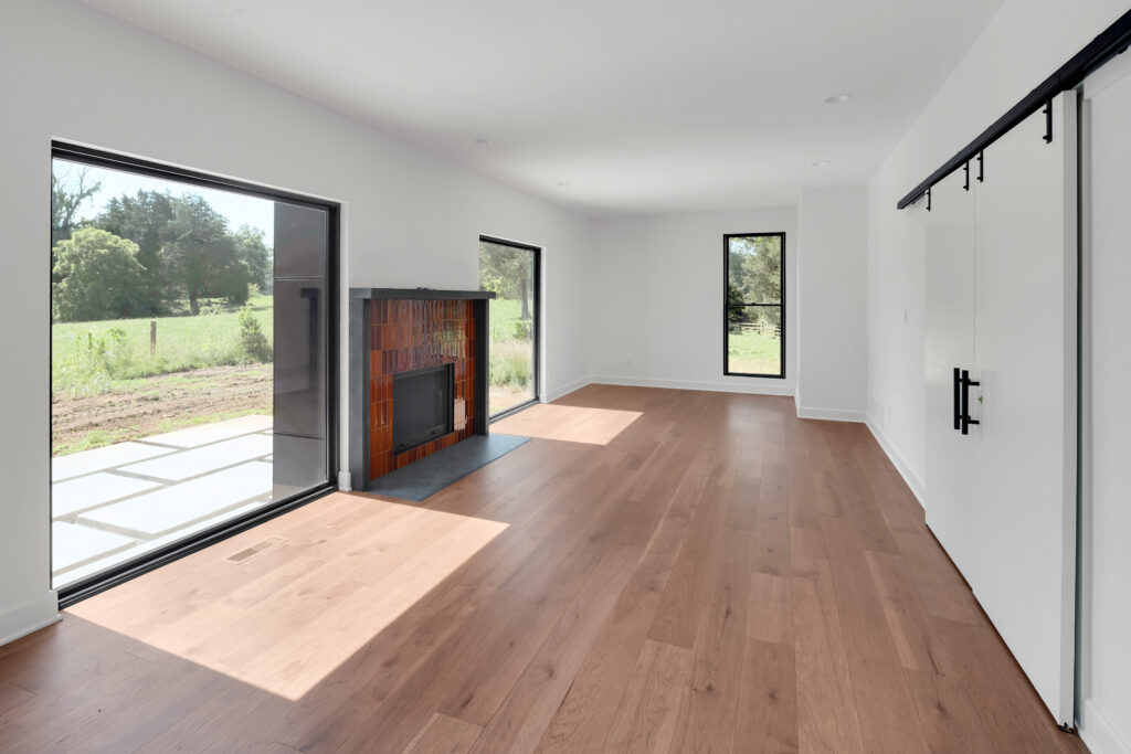 Minimalist Louisville living room with hardwood floors, large windows, and modern fireplace.