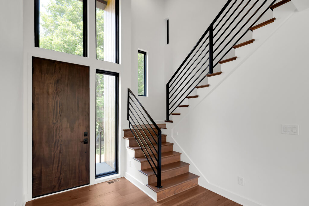 Louisville entryway design with wood door, narrow glass panels, and wood step staircase.