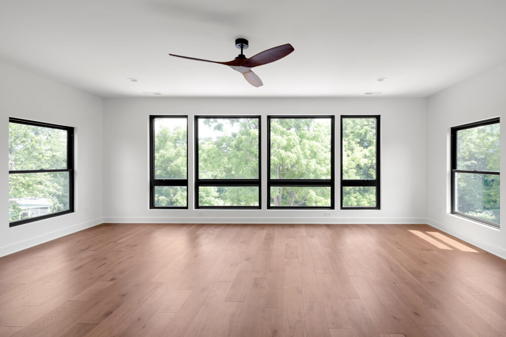 Louisville modern interior with black ceiling fan, wood floors, and big windows.