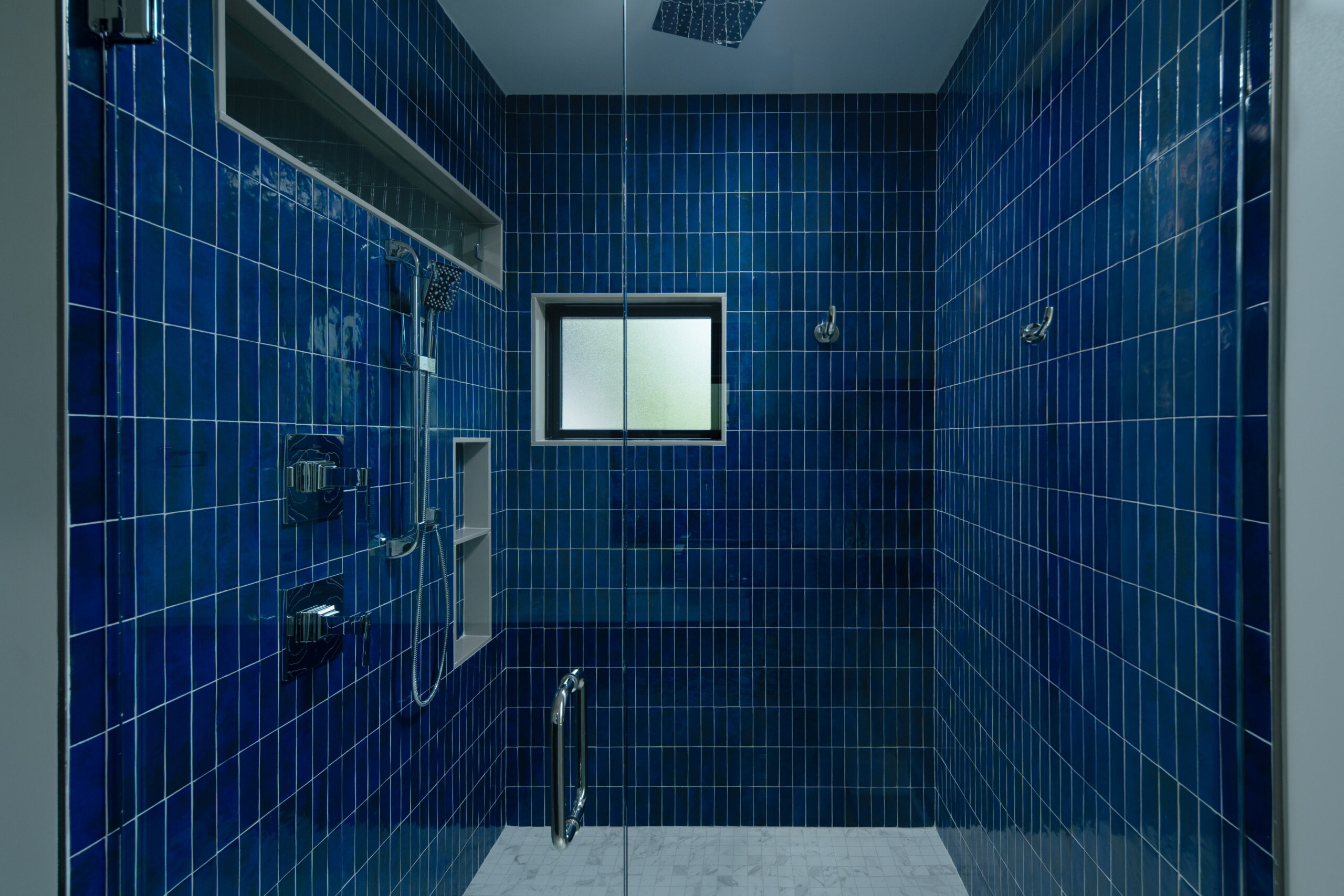 Blue tiled shower room in a custom Louisville home for a modern touch.