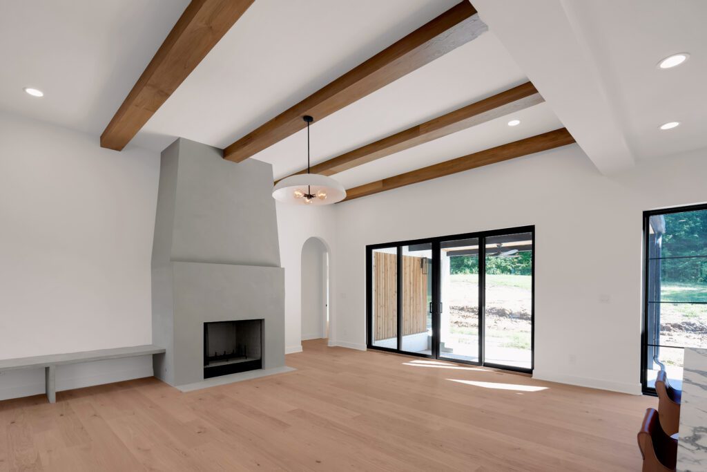 Modern Louisville living room with white walls, light wood floors, and gray fireplace.