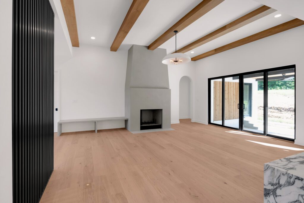 Bright Louisville living room with glass doors, exposed wood beams, and modern fireplace.