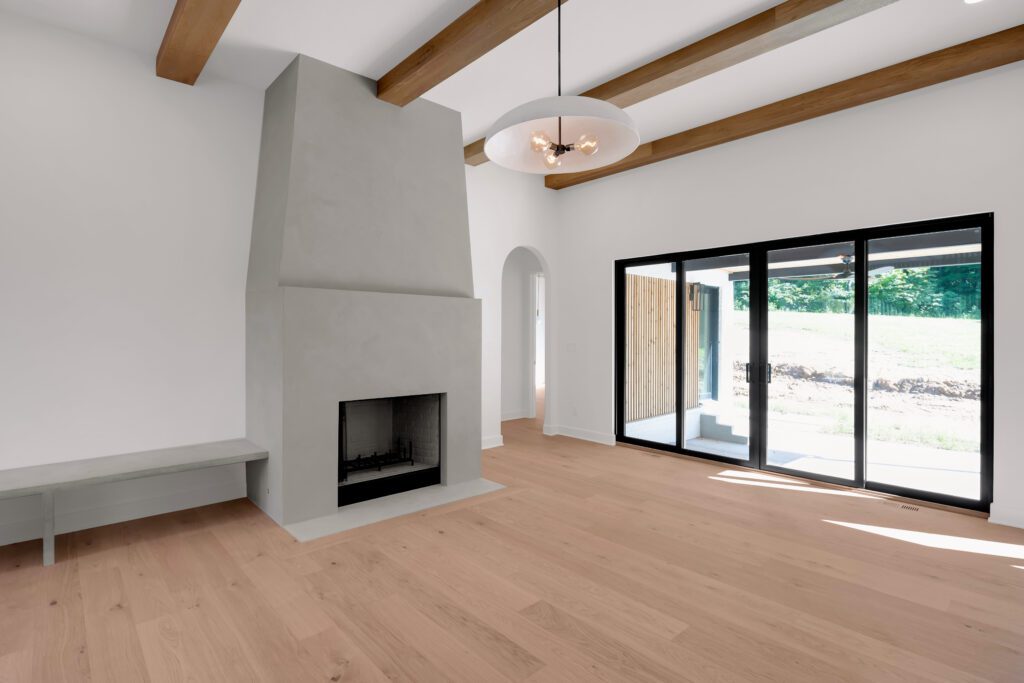 Minimalist Louisville living room with light wood flooring, fireplace, and airy layout.