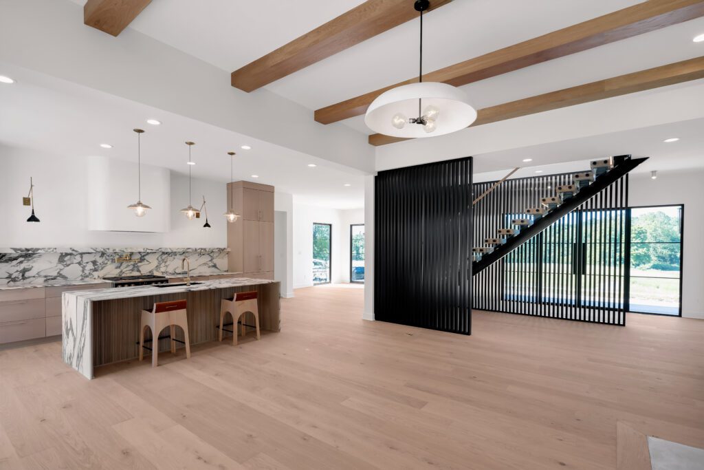 Modern Louisville kitchen with light wood floors, exposed beams, and marble backsplash.