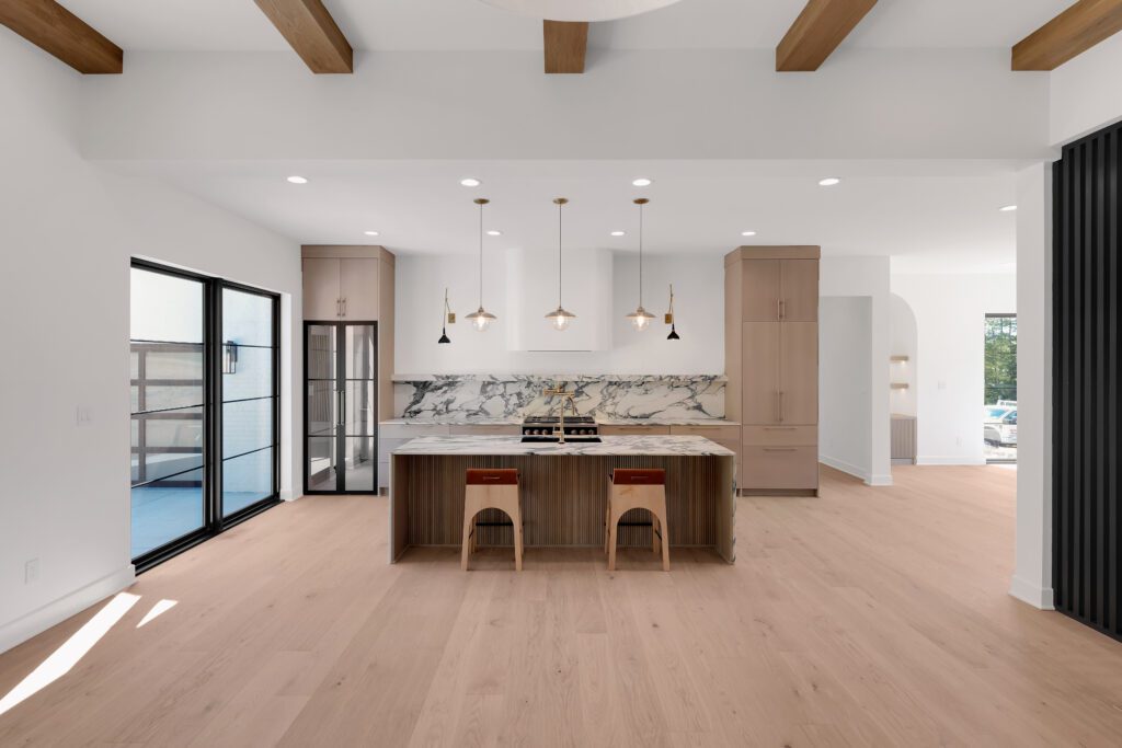 Modern Louisville kitchen with light wood floors, exposed beams, and marble backsplash.