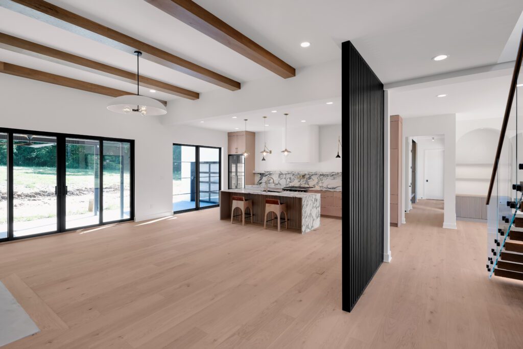 Contemporary Louisville home with open kitchen, marble island, and wood beam ceiling.