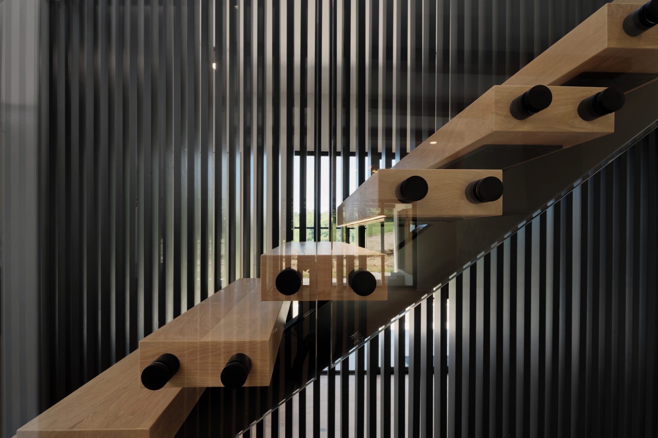 Louisville custom home floating staircase with minimalist design, wood steps, and black rods.