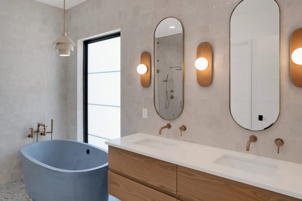 Modern Louisville bathroom with blue oval tub, wooden double vanity, and serene atmosphere.