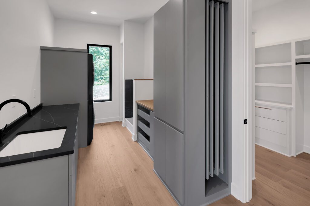 Organized Louisville laundry room with minimalist design and wooden floors.