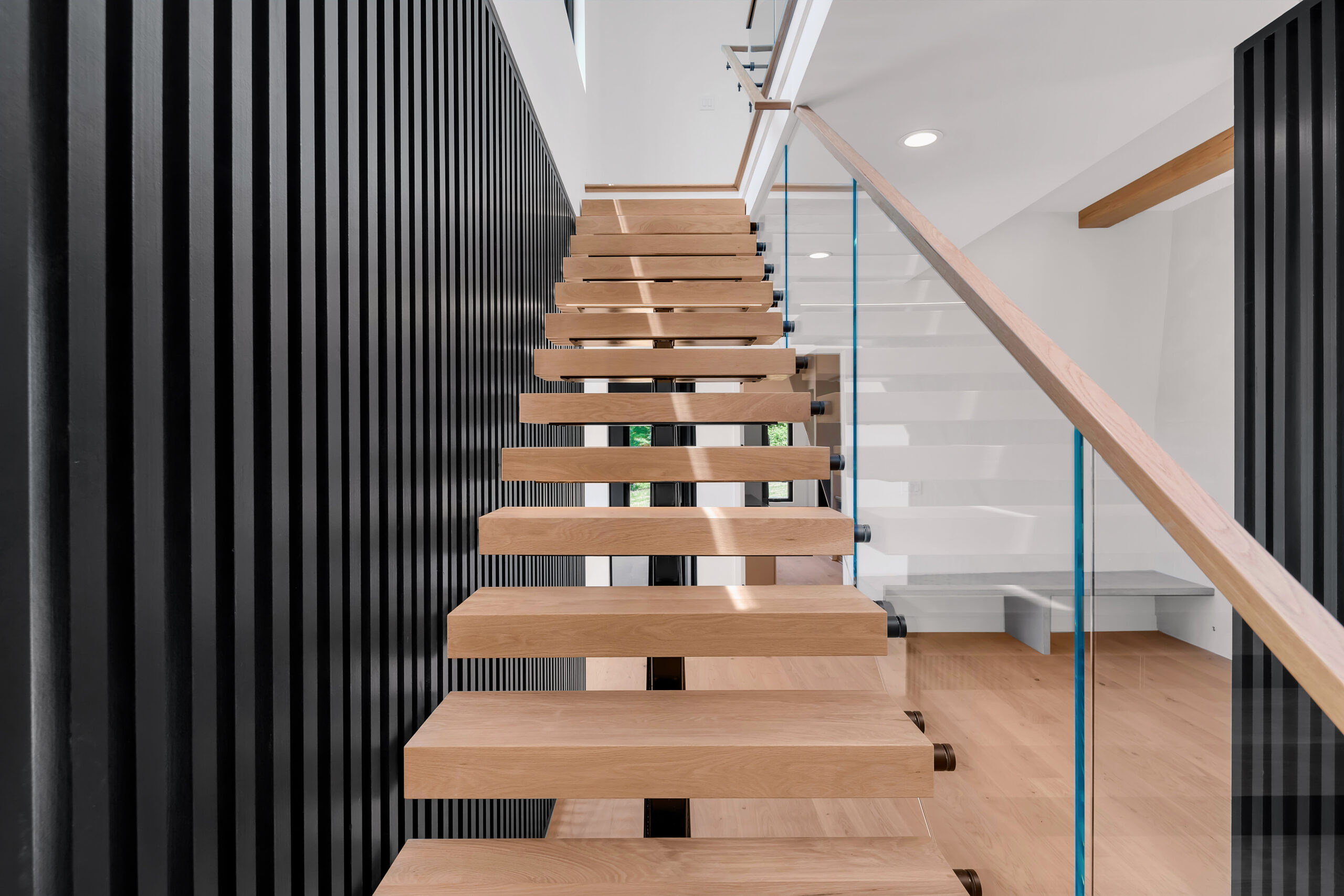Louisville staircase design with wooden floating steps, sleek glass, and slat accent wall.