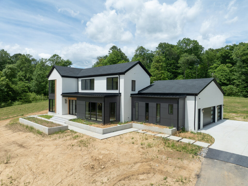 Modern Louisville home design with black and white exterior, green trees, and peaceful setting.