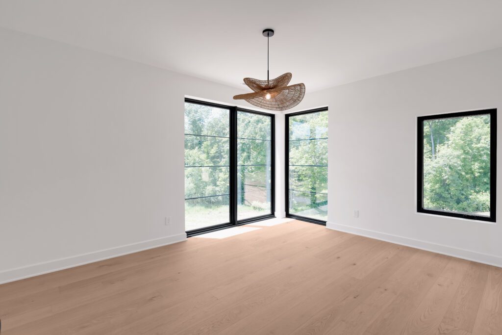 Elegant Louisville home design with corner glass views, pendant lamp, and wood flooring.