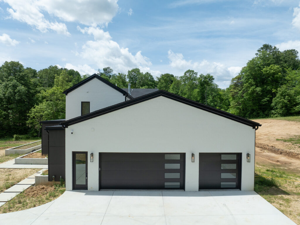 Modern Louisville home with bright white exterior and garage for three vehicles.