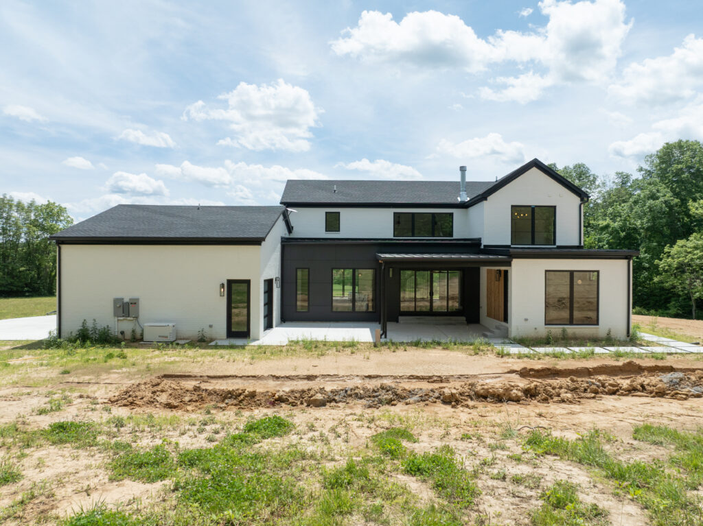 Contemporary Louisville custom home featuring black and white facade in a rural setting.